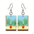 Windowsill coffee earrings — mug on a windowsill in morning light, cut-paper art, made in USA