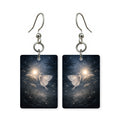 Moonlit moth earrings — moth crossing in front of a full moon, cut-paper art, made in USA