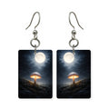 Moonlit mushroom earrings — mushrooms lit blue under a night moon, cut-paper art, made in USA