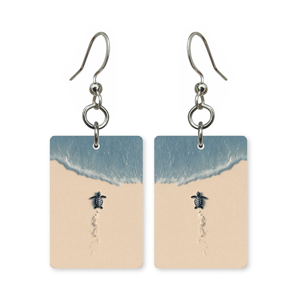 Beach hatchling earrings — baby sea turtle crossing wet sand, cut-paper art, made in USA
