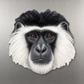 Black-and-white Colobus face wood magnet, shown on stainless steel.