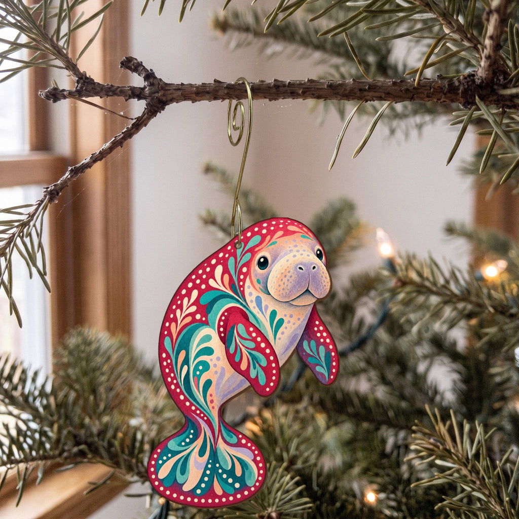 Laser-cut maple wood West Indian Manatee folk art ornament O104 hanging on a fir branch, made in USA
