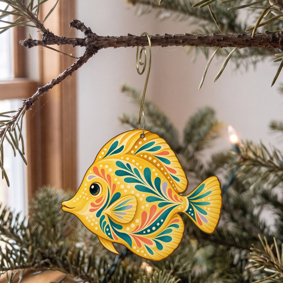 Laser-cut maple wood Yellow Tang folk art ornament O119 hanging on a fir branch, made in USA