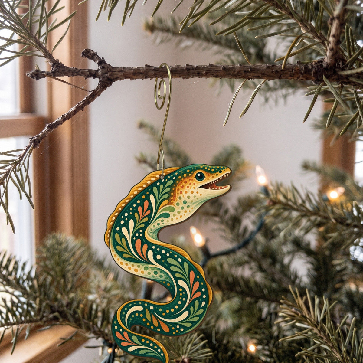Laser-cut maple wood Moray Eel folk art ornament O147 hanging on a fir branch, made in USA