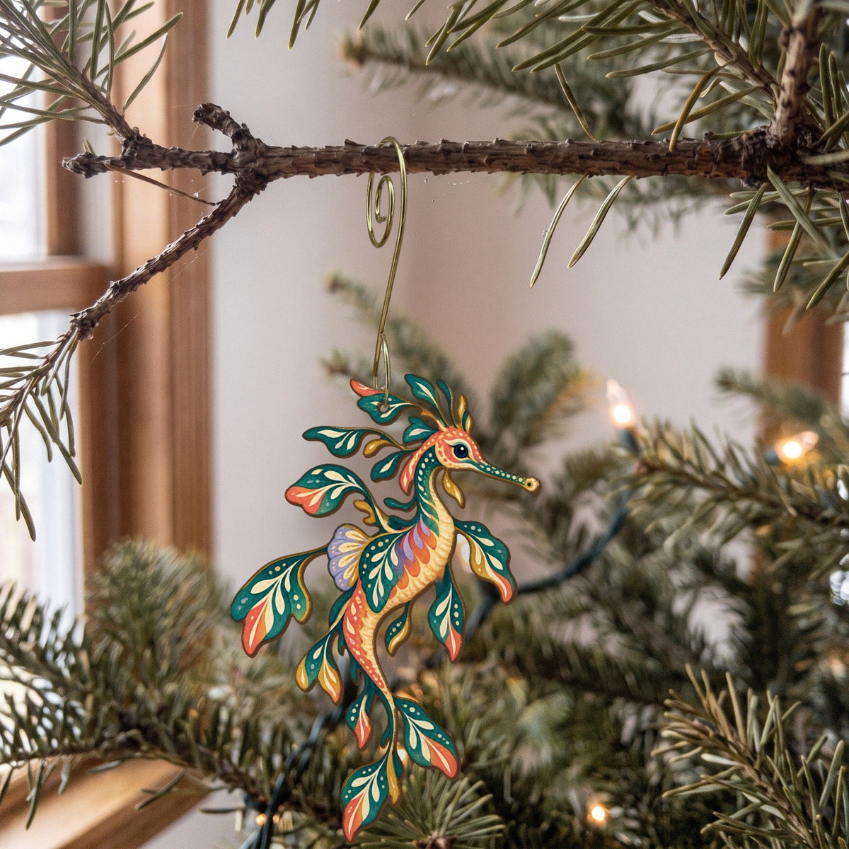 Laser-cut maple wood Weedy Seadragon folk art ornament O151 hanging on a fir branch, made in USA