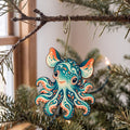 Laser-cut maple wood Dumbo Octopus folk art ornament O153 hanging on a fir branch, made in USA