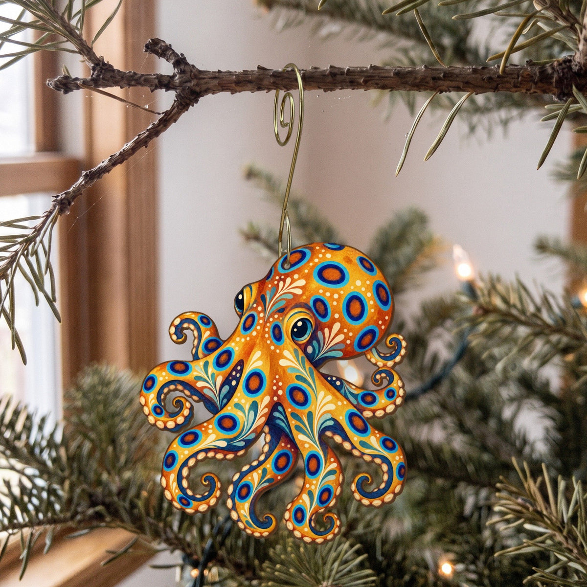 Laser-cut maple wood Blue-Ringed Octopus folk art ornament O154 hanging on a fir branch, made in USA