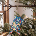 Laser-cut maple wood Bobtail Squid folk art ornament O157 hanging on a fir branch, made in USA