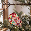 Laser-cut maple wood Chambered Nautilus folk art ornament O158 hanging on a fir branch, made in USA