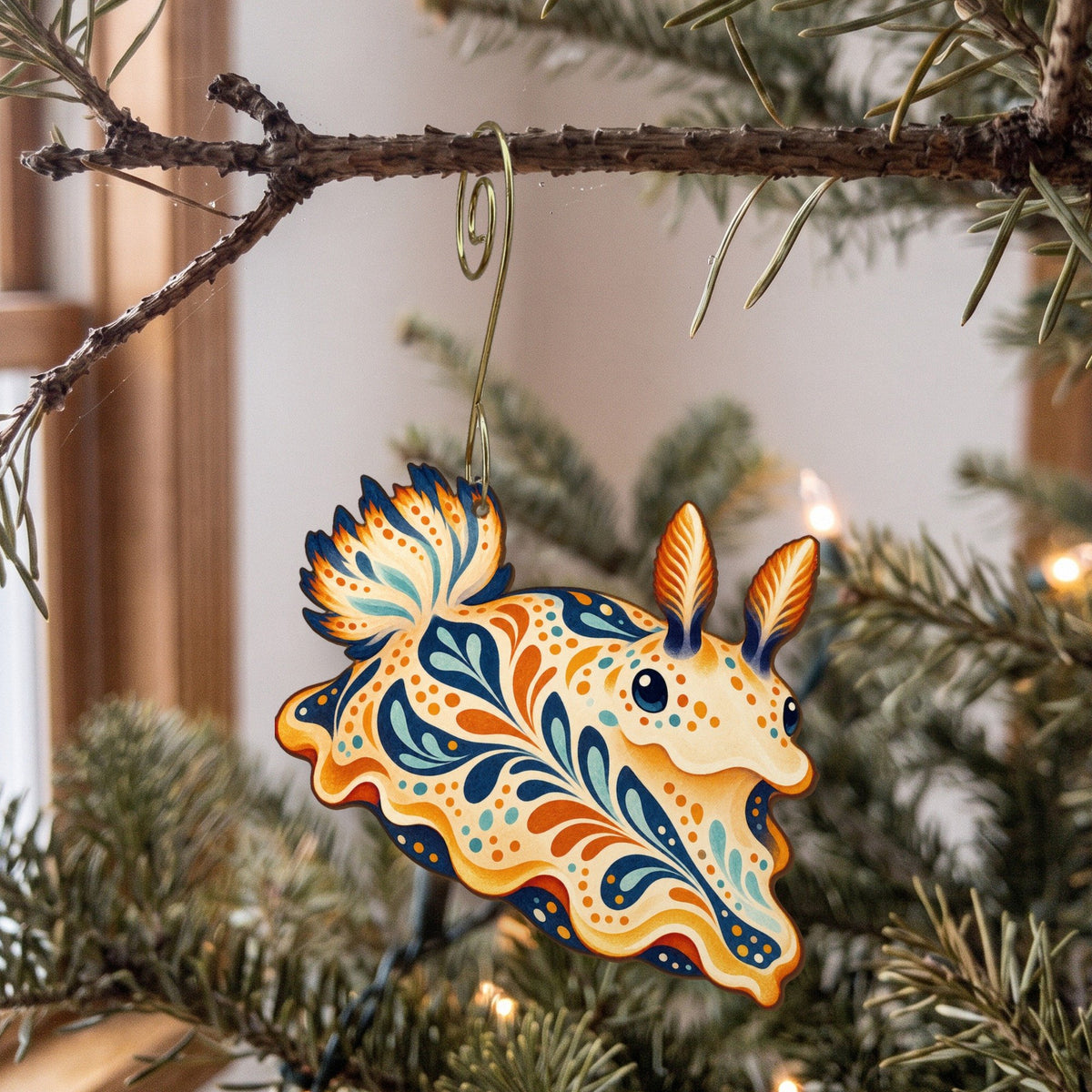 Laser-cut maple wood Sea Bunny Nudibranch folk art ornament O162 hanging on a fir branch, made in USA