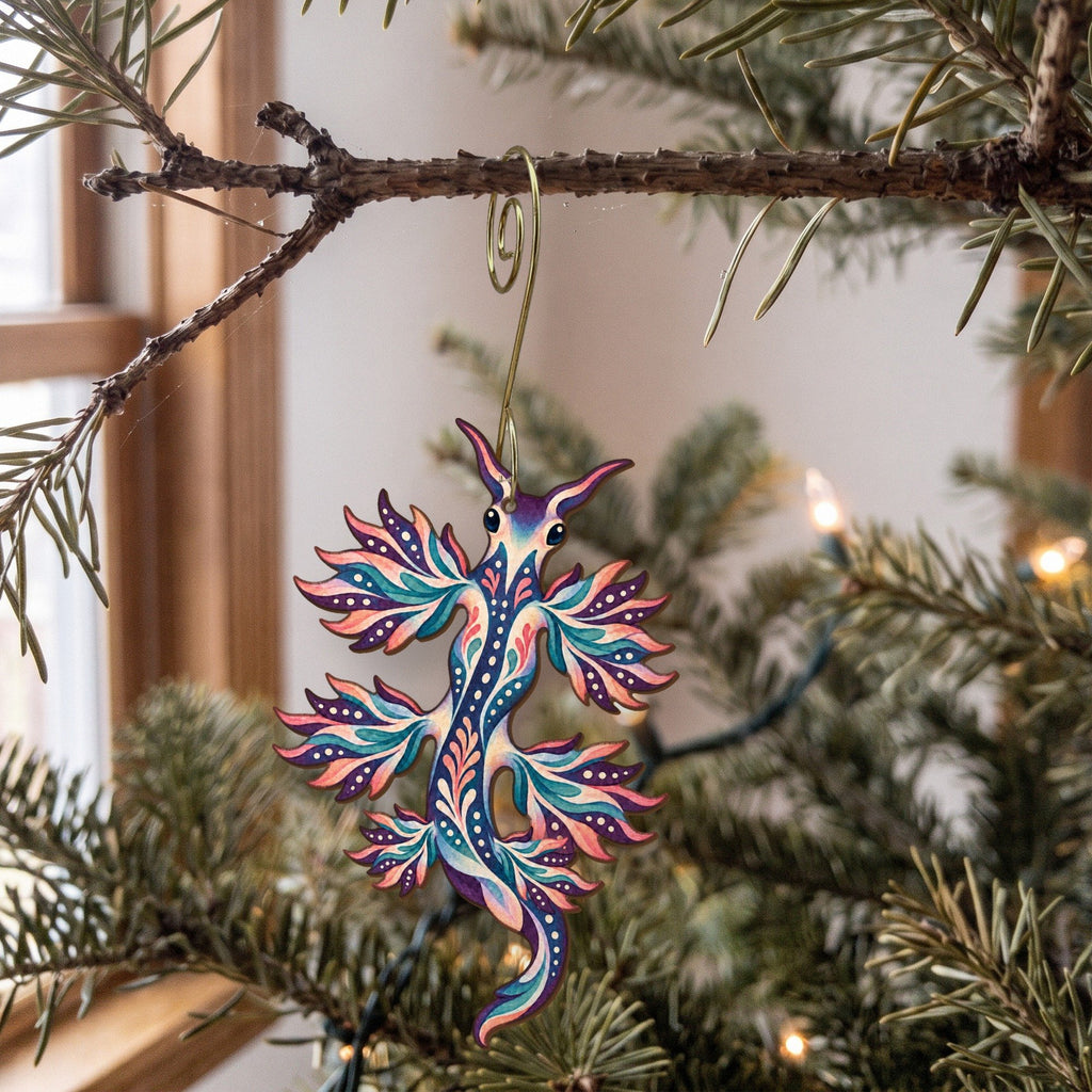 Laser-cut maple wood Blue Dragon Sea Slug folk art ornament O164 hanging on a fir branch, made in USA