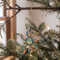 Laser-cut maple wood Brittle Star folk art ornament O167 hanging on a fir branch, made in USA