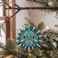 Laser-cut maple wood Sea Urchin folk art ornament O169 hanging on a fir branch, made in USA