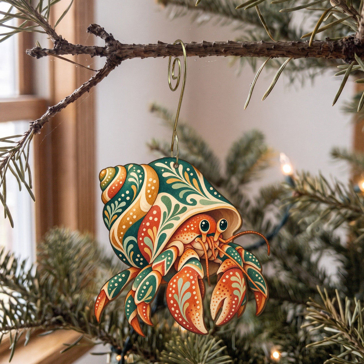 Laser-cut maple wood Hermit Crab folk art ornament O179 hanging on a fir branch, made in USA