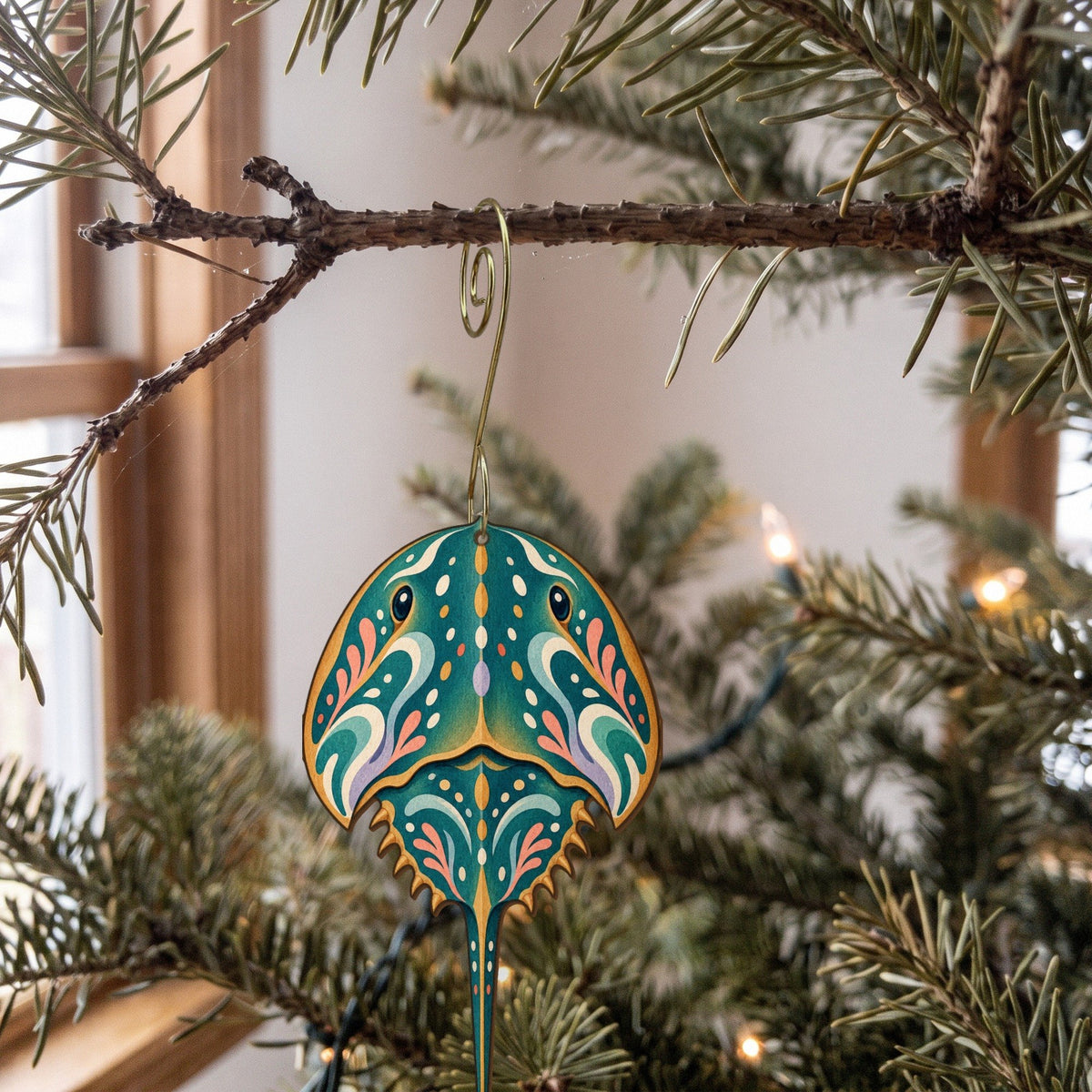 Laser-cut maple wood Horseshoe Crab folk art ornament O183 hanging on a fir branch, made in USA