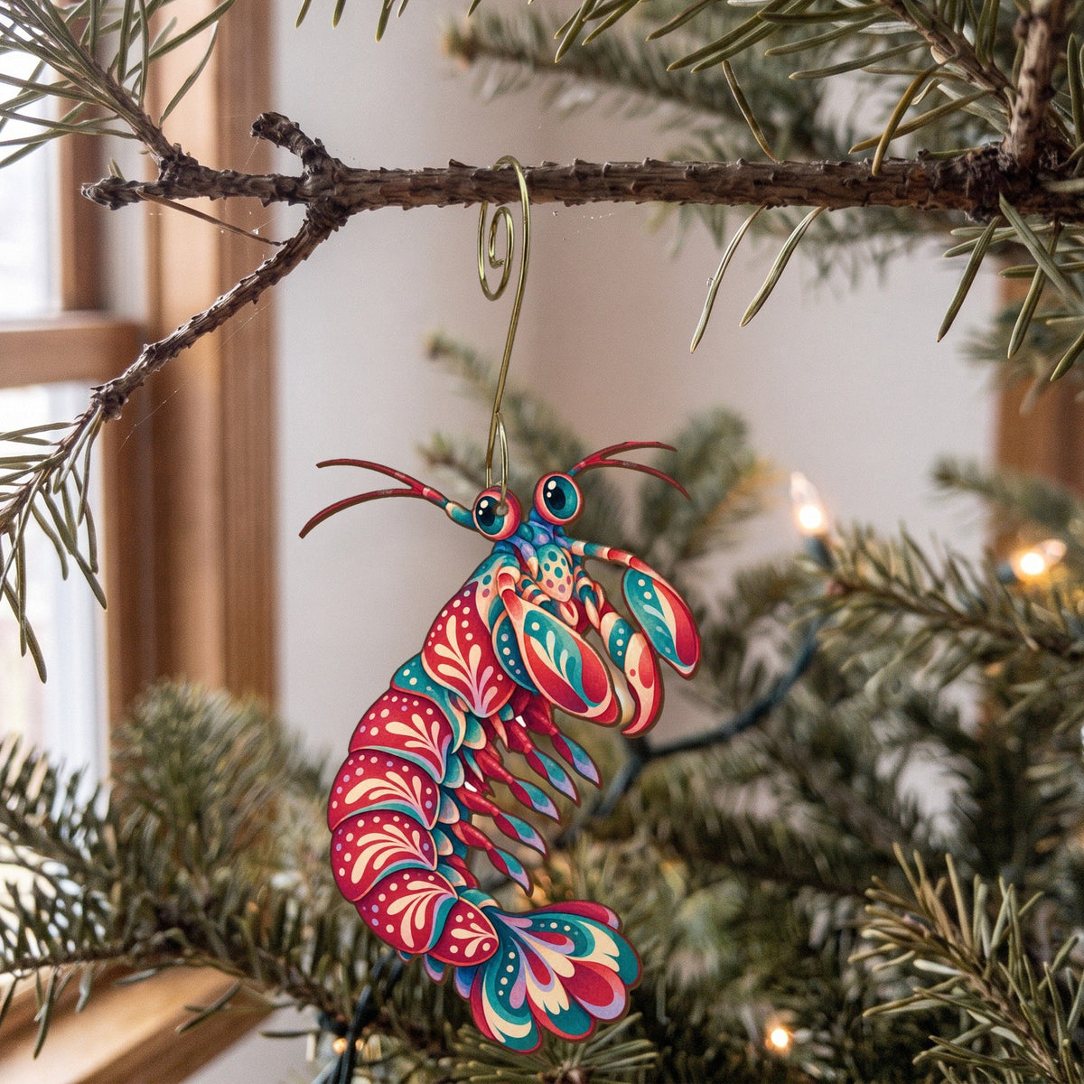 Laser-cut maple wood Mantis Shrimp folk art ornament O184 hanging on a fir branch, made in USA