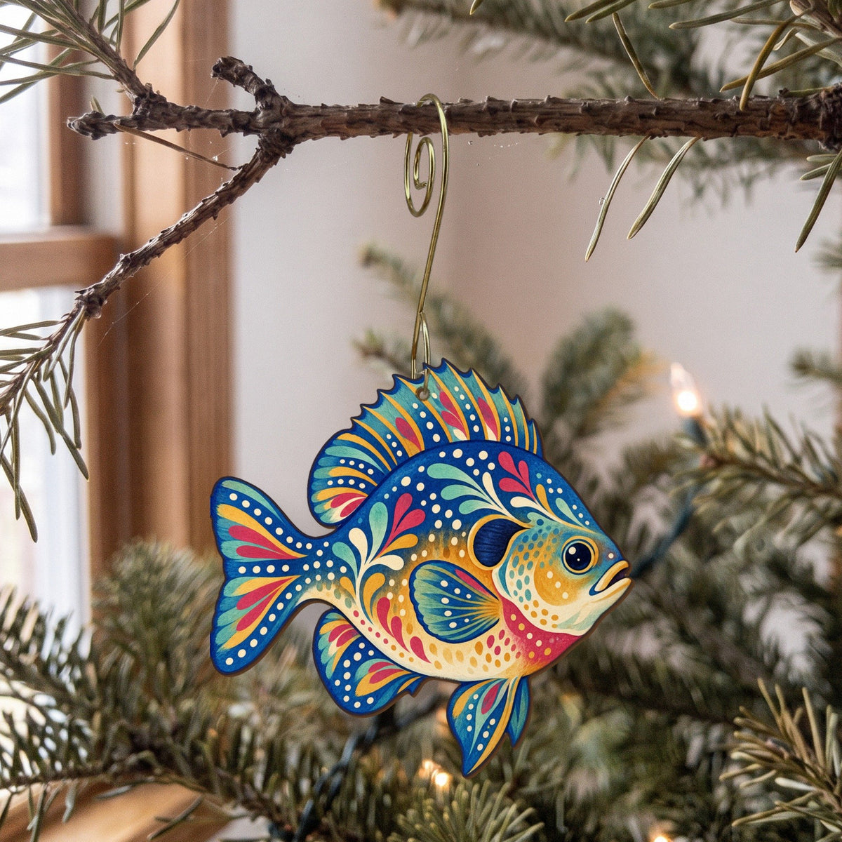 Laser-cut maple wood Bluegill folk art ornament O189 hanging on a fir branch, made in USA