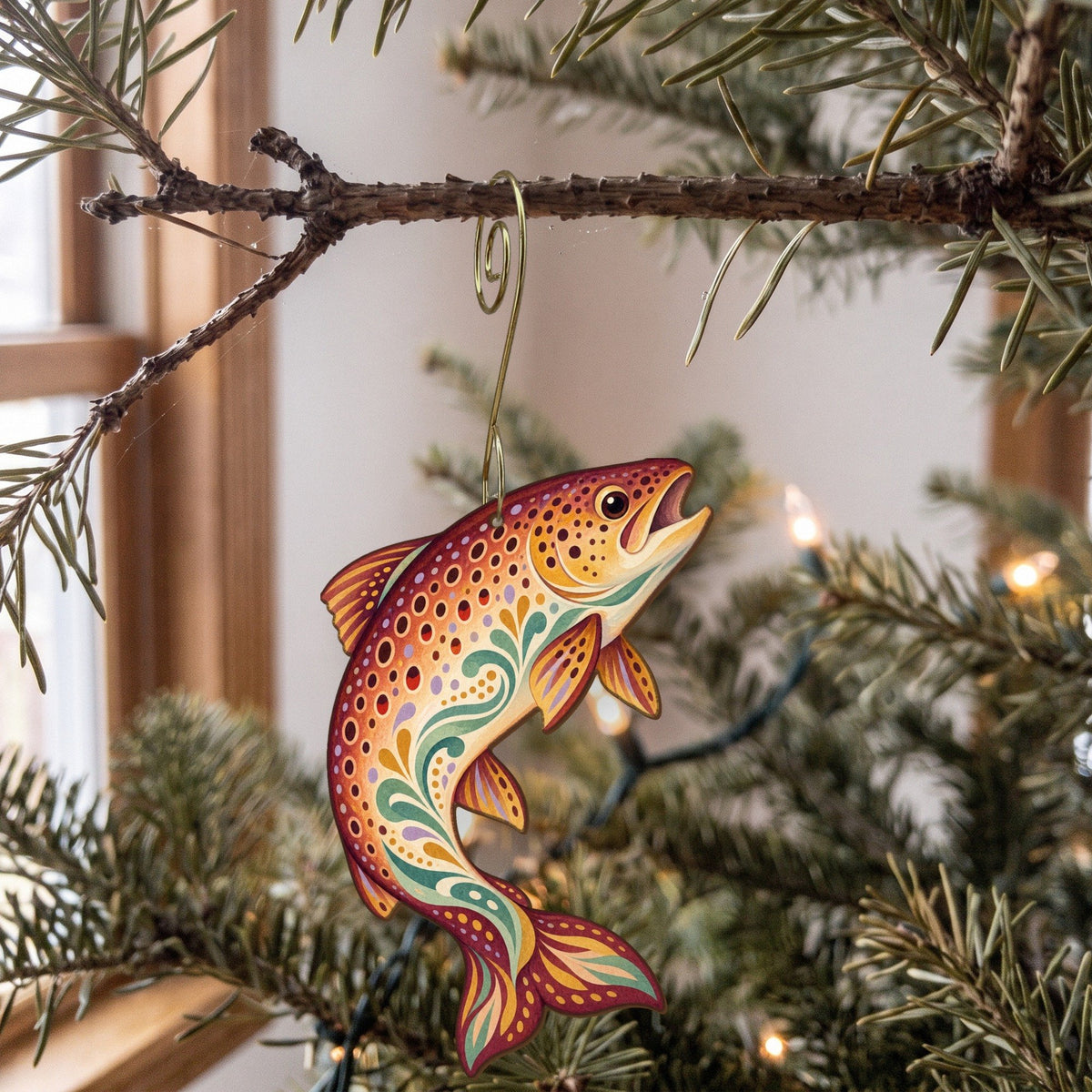 Laser-cut maple wood Brown Trout folk art ornament O198 hanging on a fir branch, made in USA