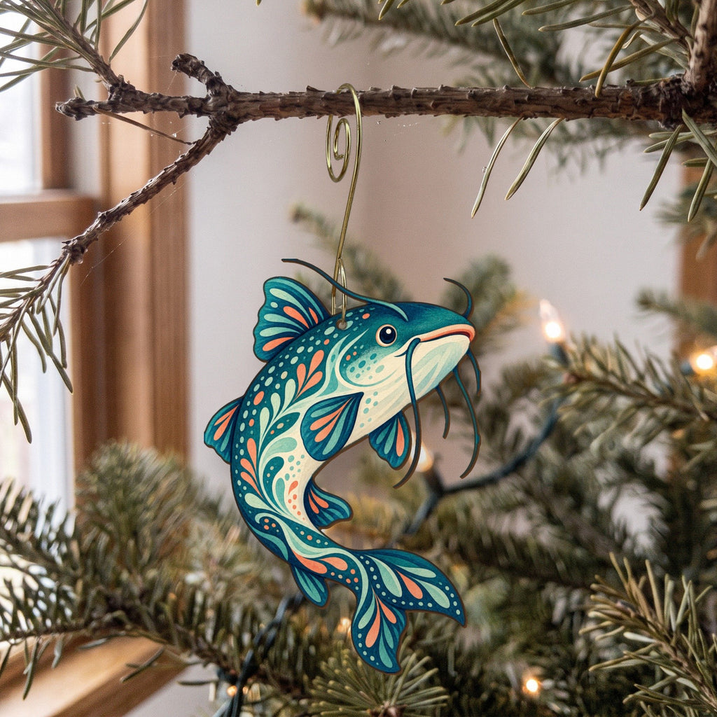 Laser-cut maple wood Channel Catfish folk art ornament O201 hanging on a fir branch, made in USA