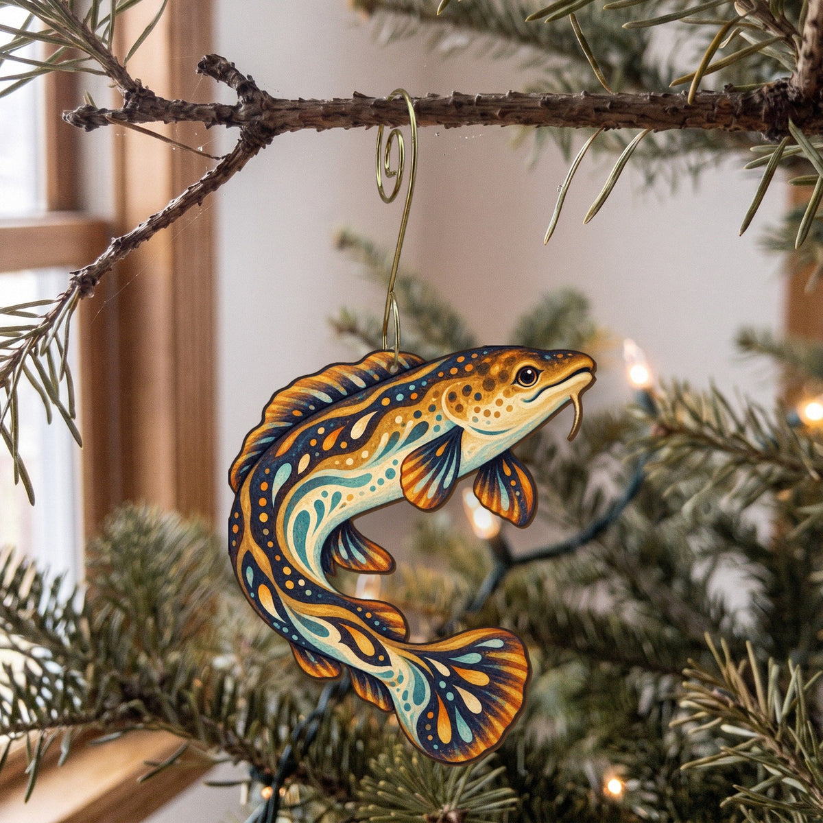 Laser-cut maple wood Burbot folk art ornament O210 hanging on a fir branch, made in USA