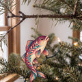 Laser-cut maple wood White Sucker folk art ornament O212 hanging on a fir branch, made in USA