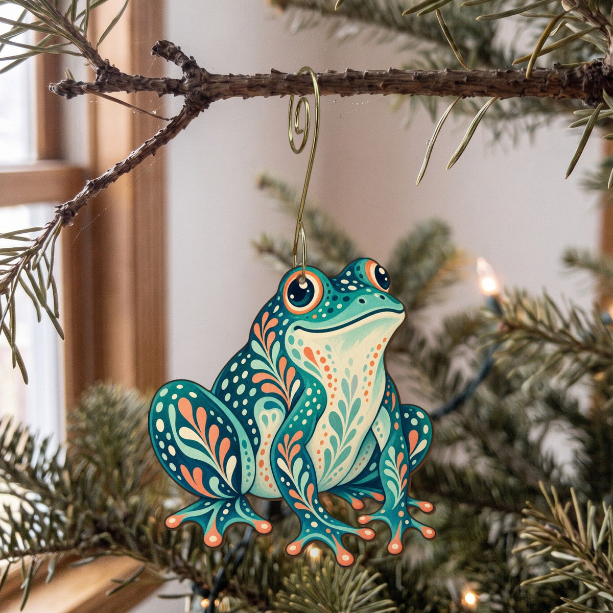 Laser-cut maple wood Bullfrog folk art ornament O217 hanging on a fir branch, made in USA