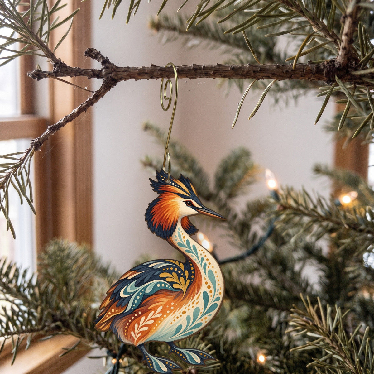 Laser-cut maple wood Great Crested Grebe folk art ornament O234 hanging on a fir branch, made in USA