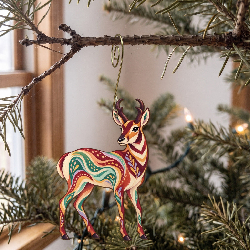 Laser-cut maple wood Pronghorn folk art ornament O238 hanging on a fir branch, made in USA