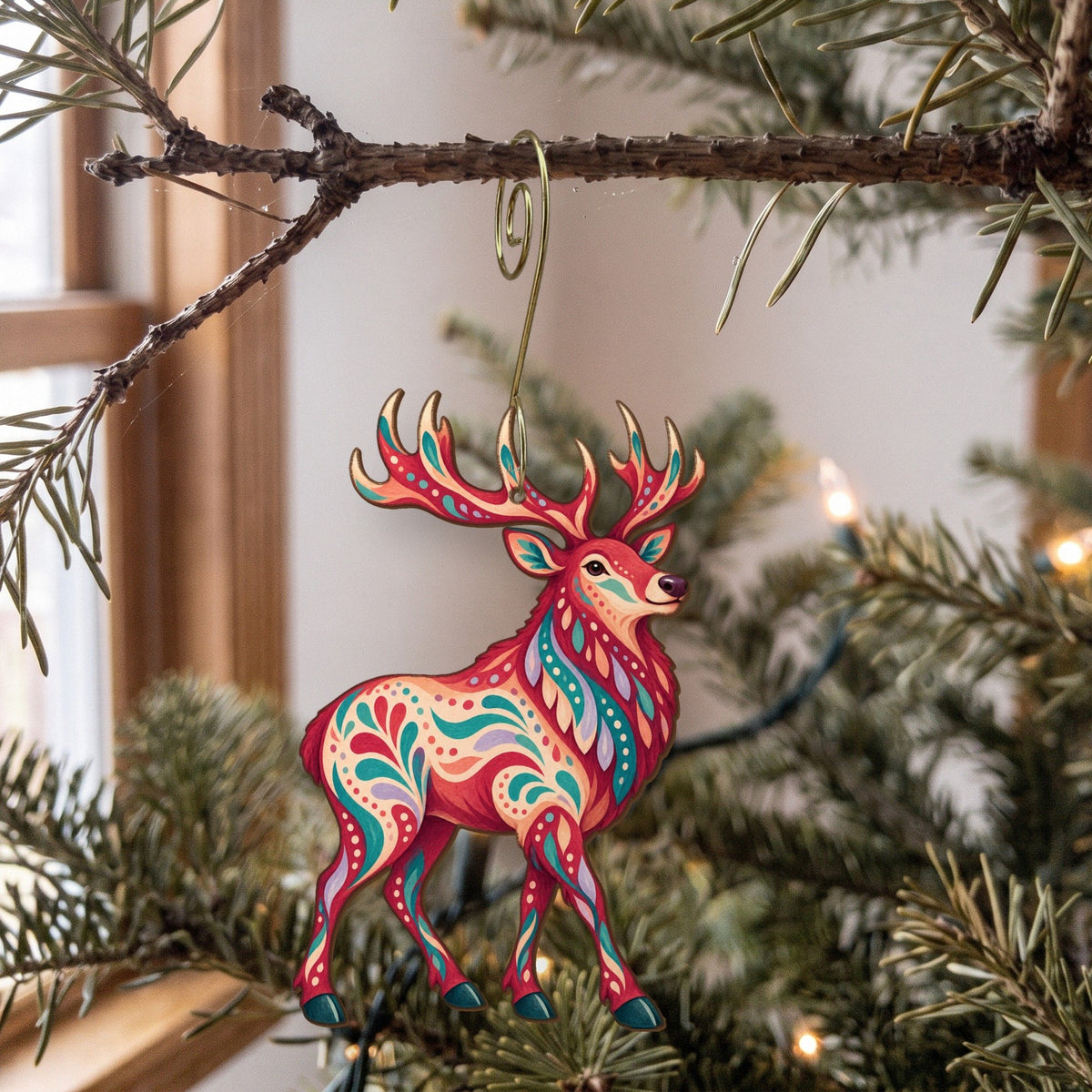Laser-cut maple wood Elk folk art ornament O240 hanging on a fir branch, made in USA