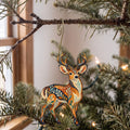 Laser-cut maple wood Mule Deer folk art ornament O242 hanging on a fir branch, made in USA
