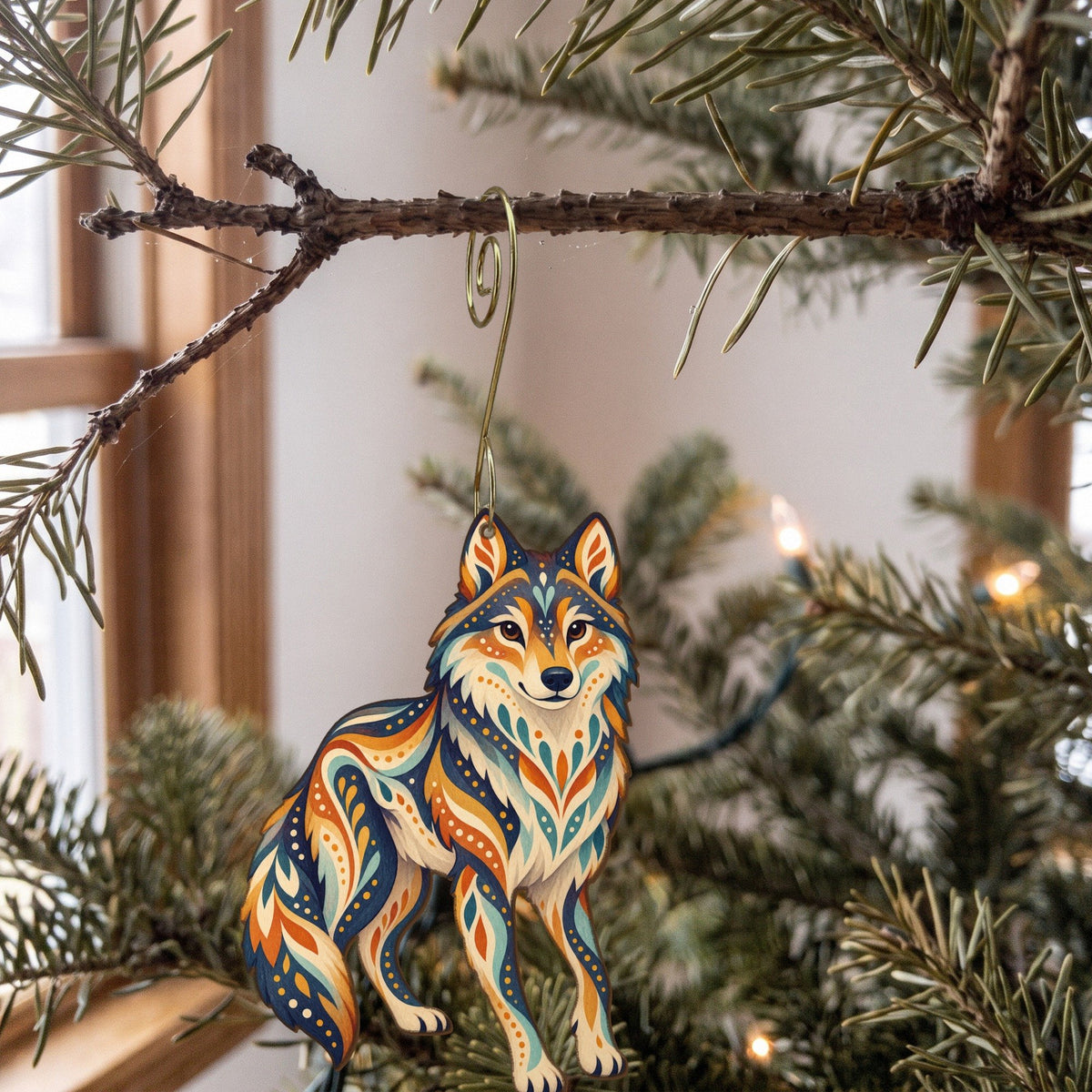 Laser-cut maple wood Gray Wolf folk art ornament O250 hanging on a fir branch, made in USA