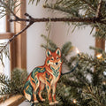 Laser-cut maple wood Red Wolf folk art ornament O251 hanging on a fir branch, made in USA
