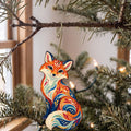 Laser-cut maple wood Red Fox folk art ornament O253 hanging on a fir branch, made in USA
