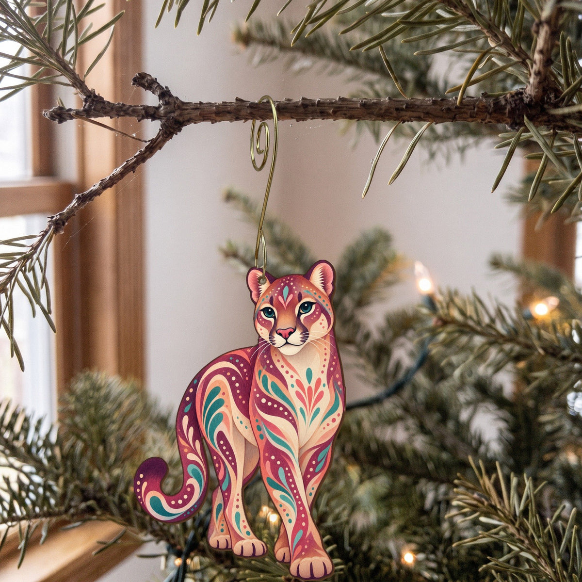 Laser-cut maple wood Cougar folk art ornament O260 hanging on a fir branch, made in USA