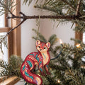 Laser-cut maple wood American Marten folk art ornament O264 hanging on a fir branch, made in USA