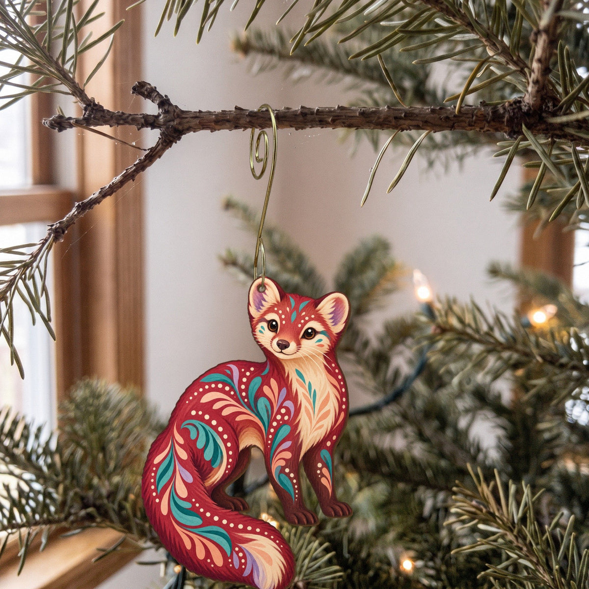 Laser-cut maple wood American Marten folk art ornament O264 hanging on a fir branch, made in USA
