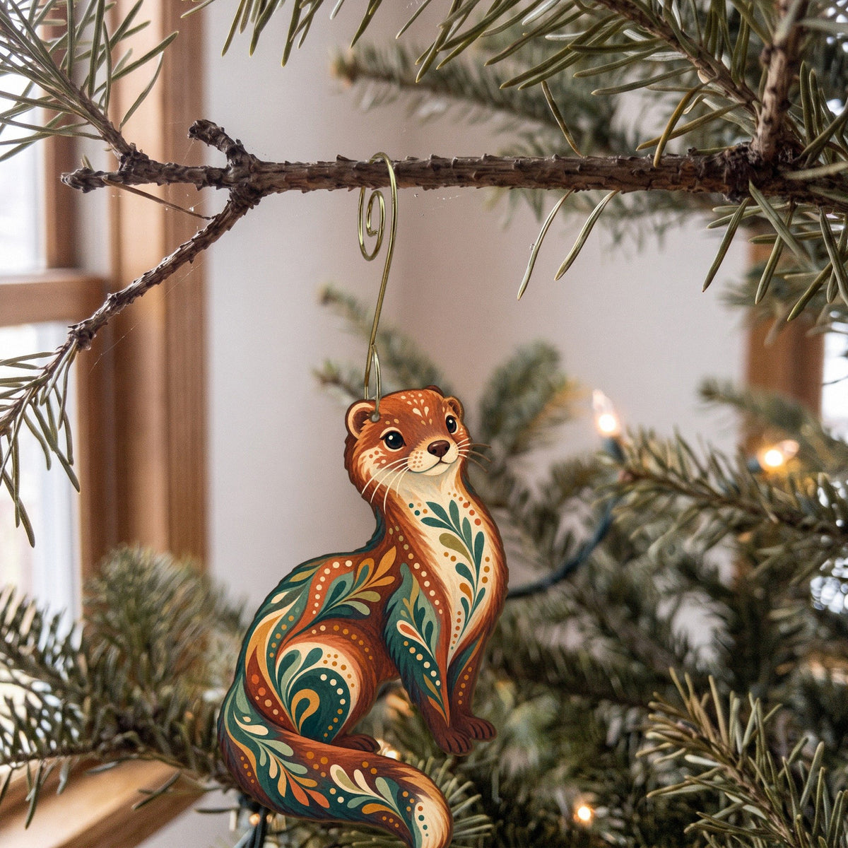 Laser-cut maple wood Mink folk art ornament O267 hanging on a fir branch, made in USA