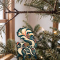 Laser-cut maple wood Spotted Skunk folk art ornament O271 hanging on a fir branch, made in USA