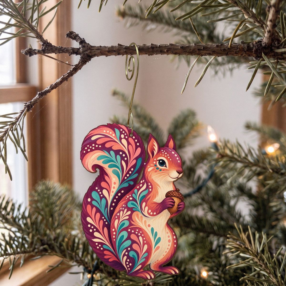 Laser-cut maple wood Fox Squirrel folk art ornament O284 hanging on a fir branch, made in USA