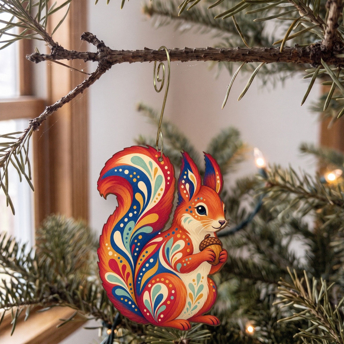 Laser-cut maple wood Red Squirrel folk art ornament O285 hanging on a fir branch, made in USA