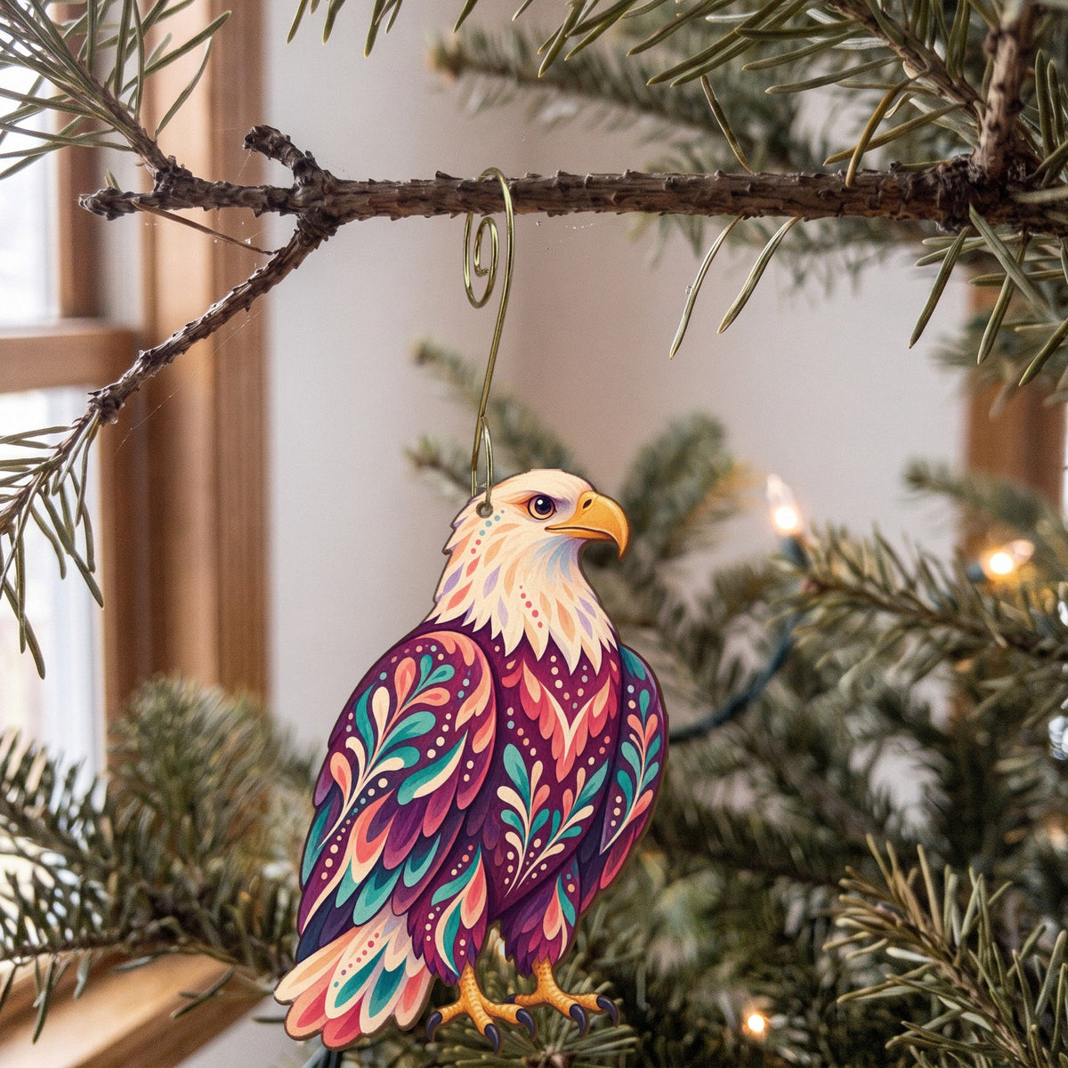 Laser-cut maple wood Bald Eagle folk art ornament O292 hanging on a fir branch, made in USA