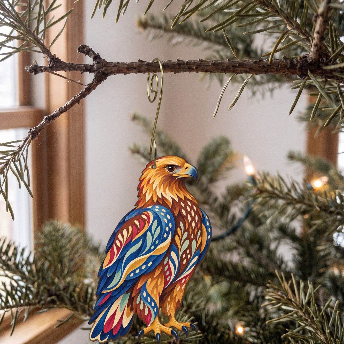 Laser-cut maple wood Golden Eagle folk art ornament O293 hanging on a fir branch, made in USA