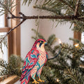 Laser-cut maple wood Peregrine Falcon folk art ornament O296 hanging on a fir branch, made in USA