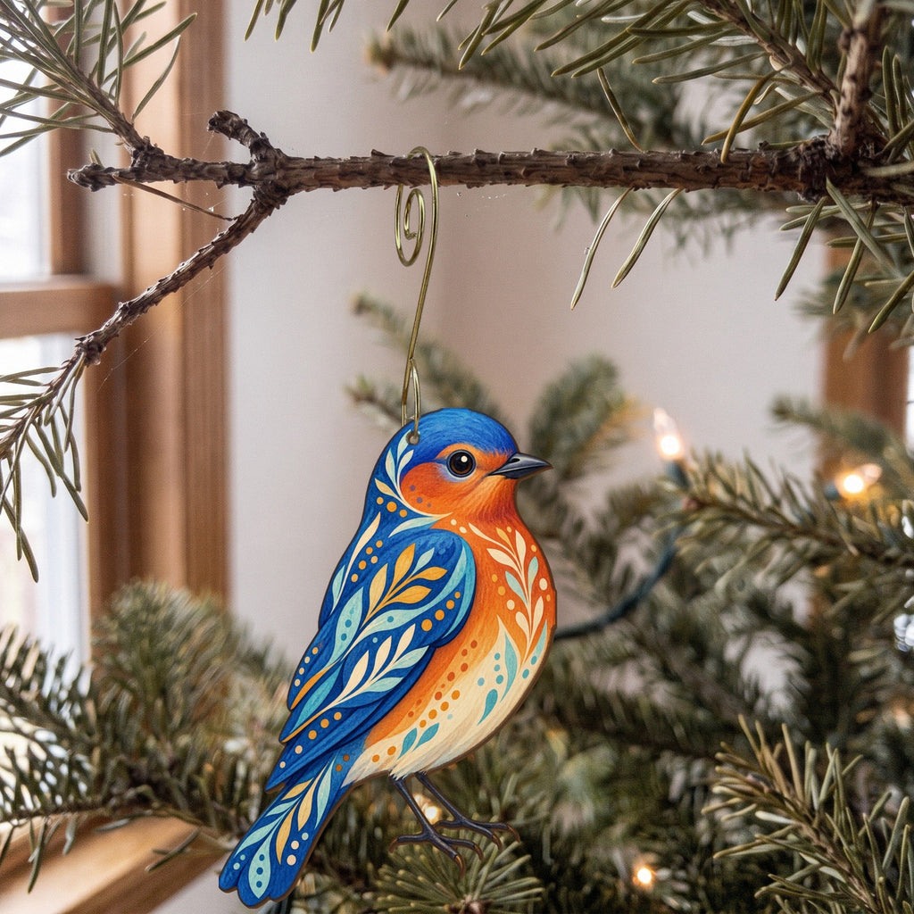 Laser-cut maple wood Western Bluebird folk art ornament O306 hanging on a fir branch, made in USA