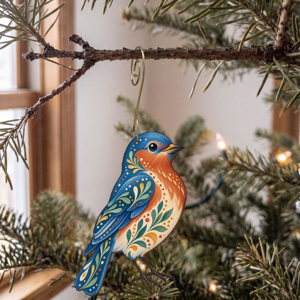 Laser-cut maple wood Eastern Bluebird folk art ornament O307 hanging on a fir branch, made in USA