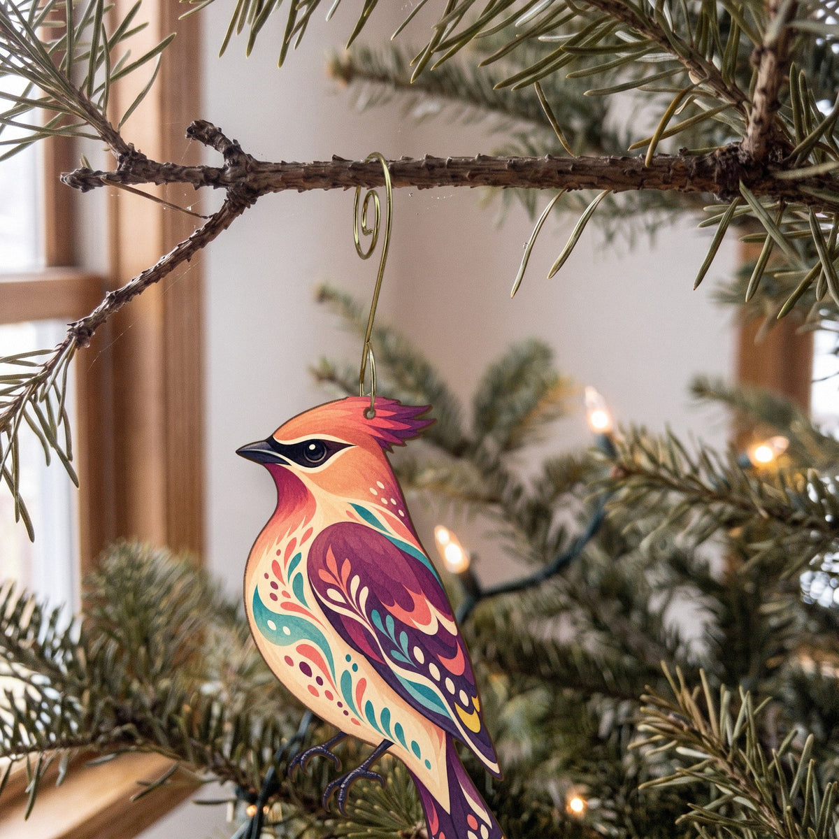 Laser-cut maple wood Cedar Waxwing folk art ornament O308 hanging on a fir branch, made in USA