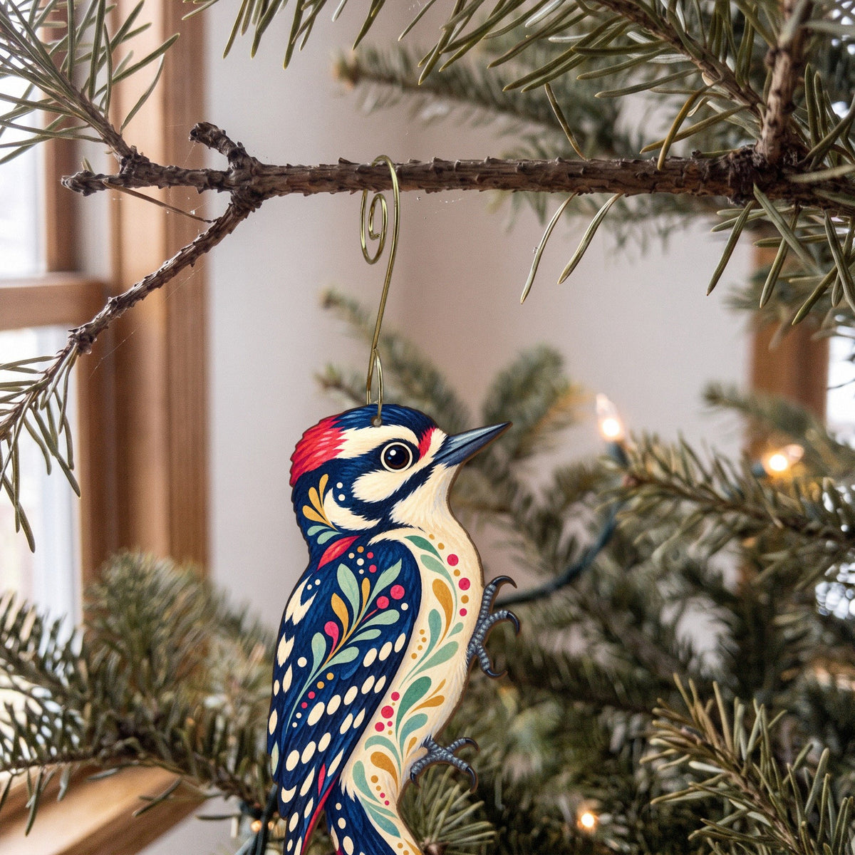 Laser-cut maple wood Downy Woodpecker folk art ornament O317 hanging on a fir branch, made in USA