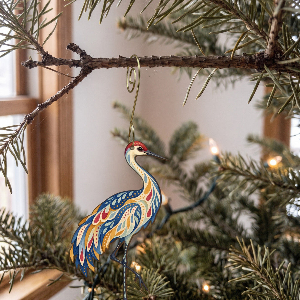 Laser-cut maple wood Sandhill Crane folk art ornament O325 hanging on a fir branch, made in USA