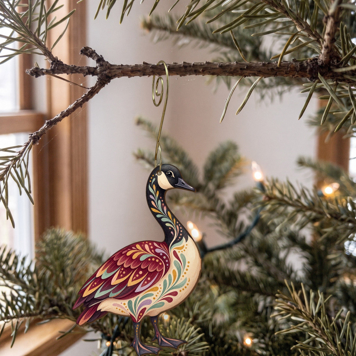 Laser-cut maple wood Canada Goose folk art ornament O326 hanging on a fir branch, made in USA