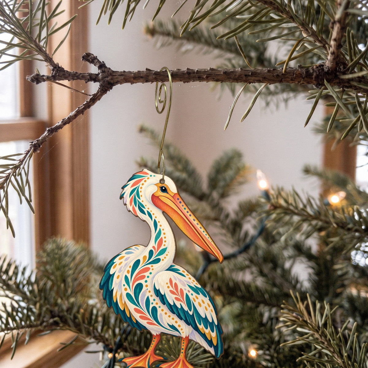 Laser-cut maple wood American White Pelican folk art ornament O327 hanging on a fir branch, made in USA